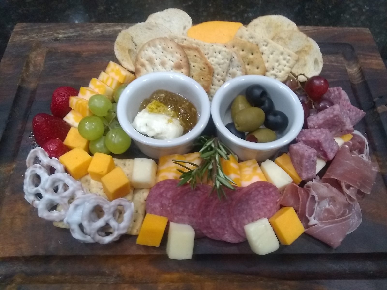 Charcuterie board arranged on a wooden serving board